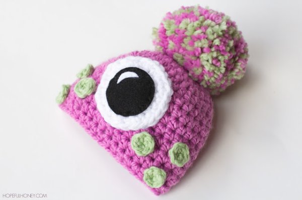 A pink crochet one-eyed monster hat.