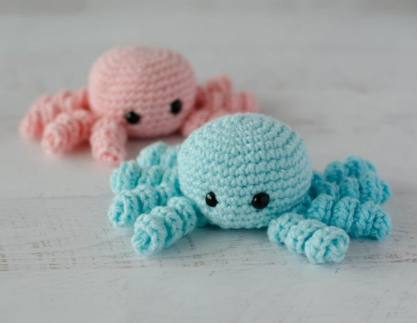 Two crochet spiders in pastel colours.