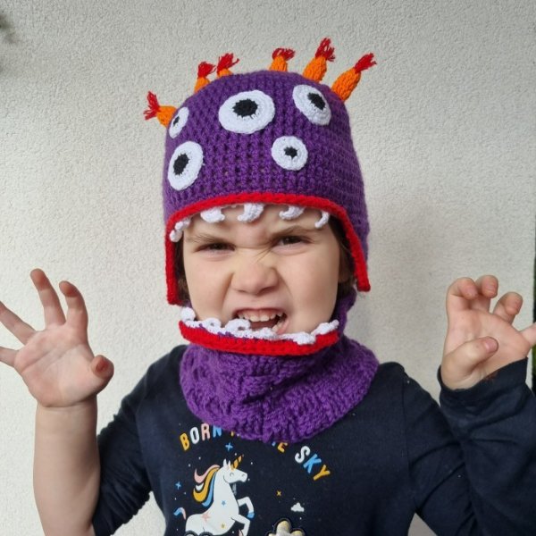 A purple and orange crochet Halloween monster hat.