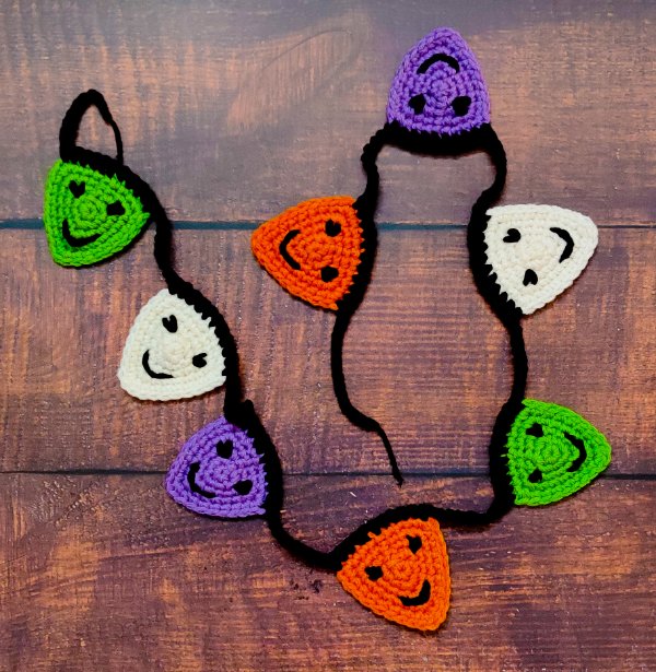 A purple, green, orange, and white crochet Halloween garland.