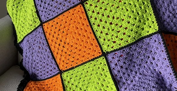 A granny square blanket in Halloween-themed colours.