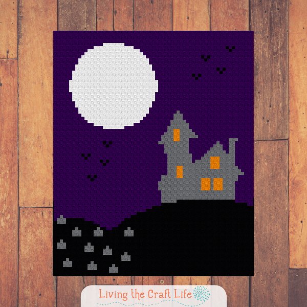 A crchet Halloween blanket featuring a haunted house and a moon.