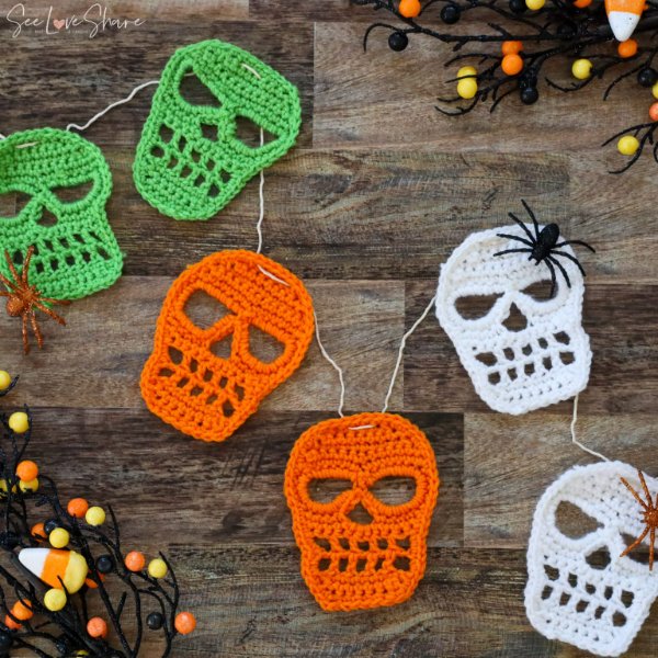 A crochet garland with neon coloured crochet skull motifs.