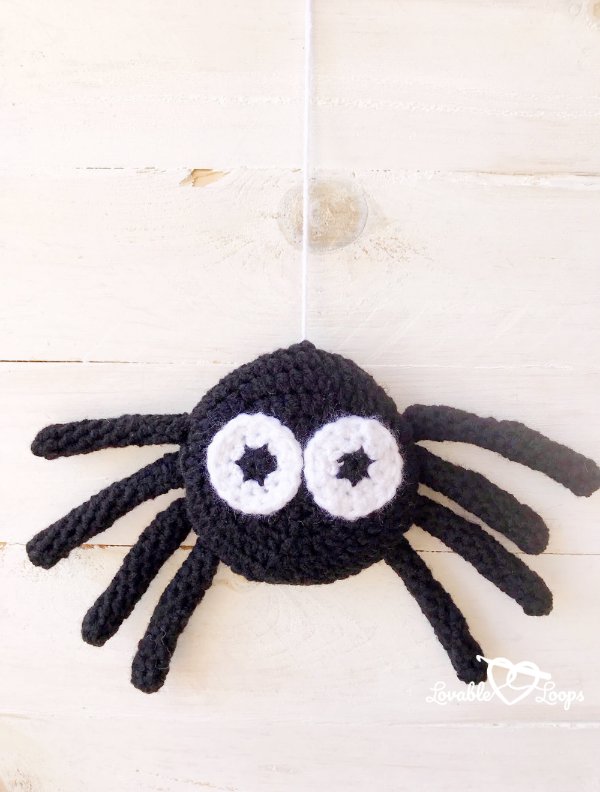 A small crochet spider with big white eyes.