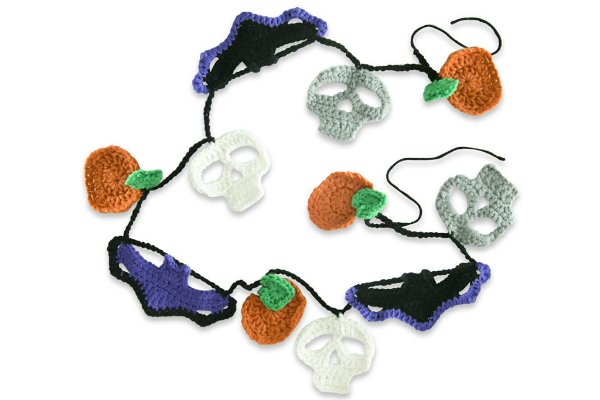 A crochet garland with bat, skull, and pumpkin motifs.