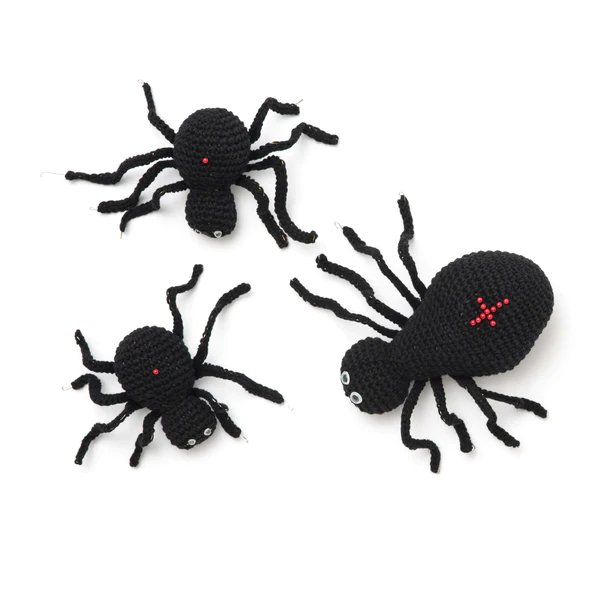Three black crochet spiders with red backs.