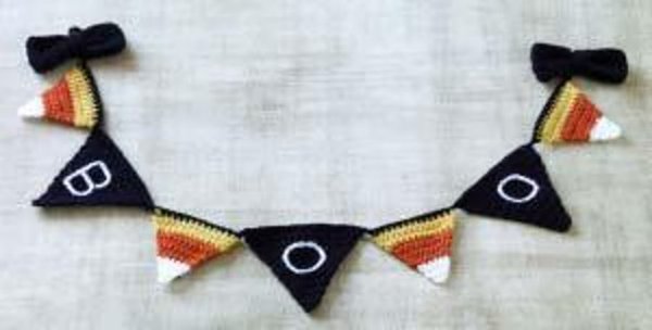 A candy corn and boo crochet pennant.