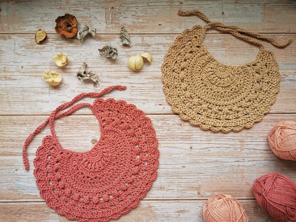 Two crochet bibs on a timber backgound.