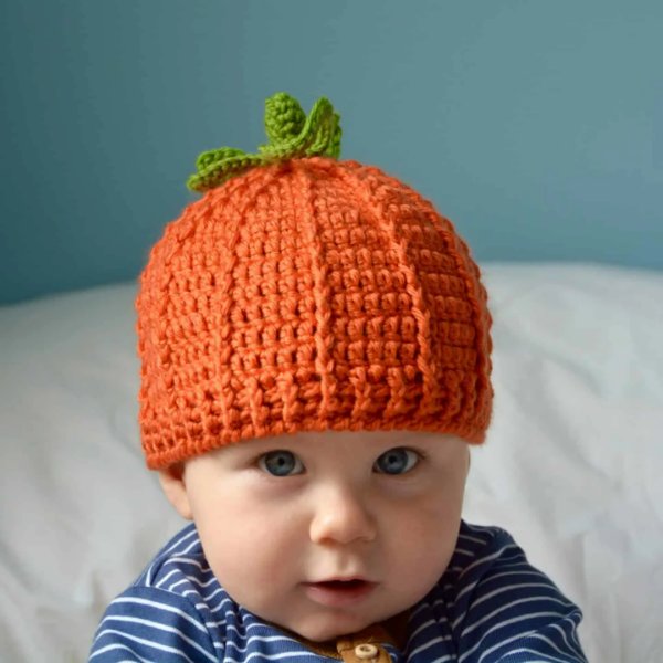 A baby wearing a cute crochet pumpkin hat.