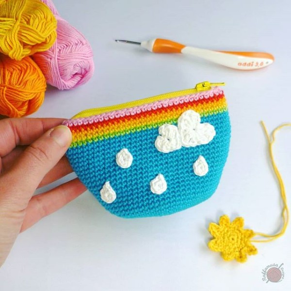 A brightly coloured crochet coin pouch with a zipper.