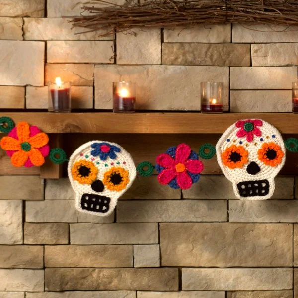 A crochet skull butning on a mantlepiece.
