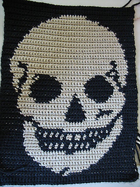 A tapestry crochet skull blanket.