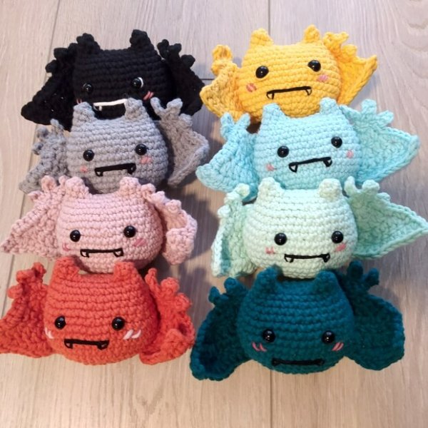 A collection of small crochet bats in rainbow colours.