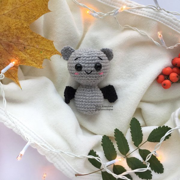 A tiny grey and black crochet bat amigurumi.