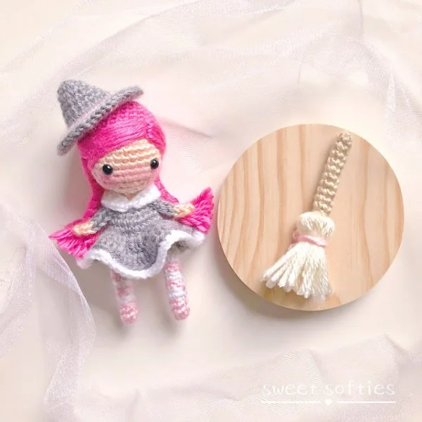 A crochet witch toy in soft pastels with bright pink hair.