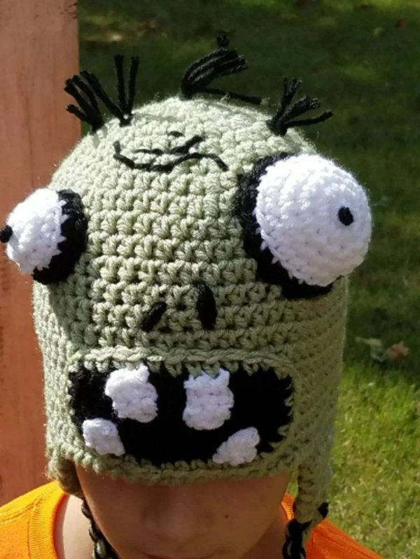 A child wearing a crochet zombie hat with bug eyes.