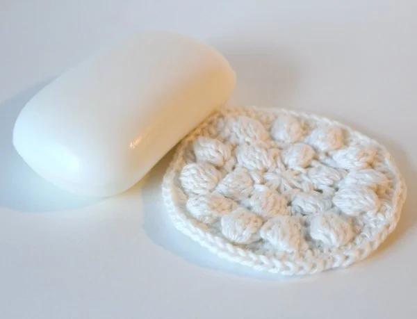 A white crochet cotton round and a bar of soap.