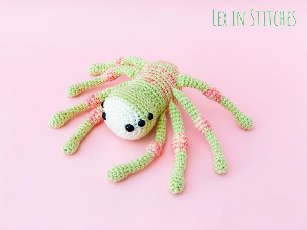 A cute, pastel coloured crochet spider toy.
