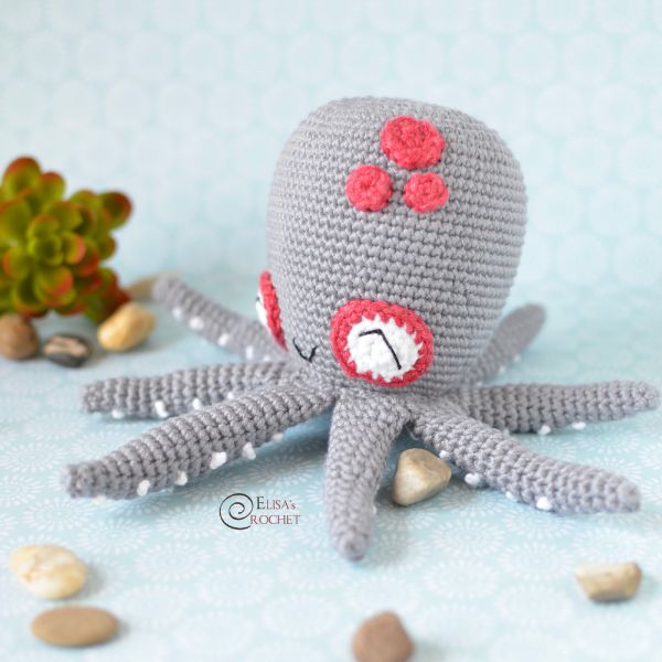 A grey crochet octopus with little white suckers on her tentacles.