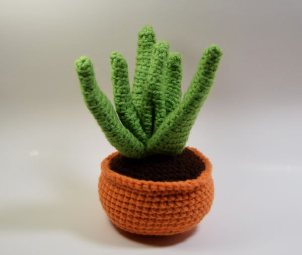 A crochet aloe vera plant in a teraccotta coloured crochet pot.