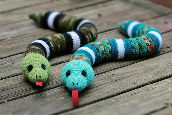 Two striped crochet snakes with big red tongues.