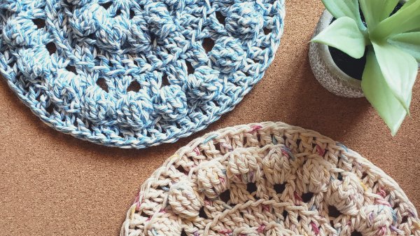 A closeup of two crochet trivets featuring the bobble stitch.