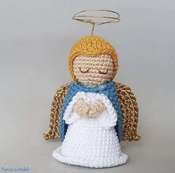 A crochet angel tree topper with a gold halo.