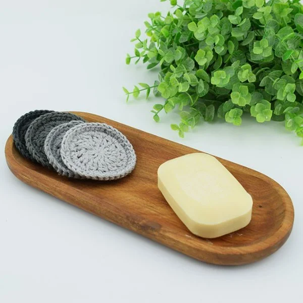 Grey crochet makeup remover pads and soap on a timber tray.