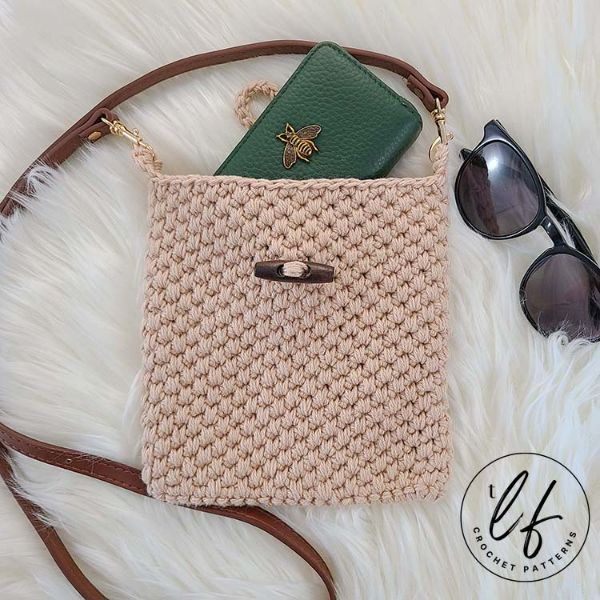 Textured crochet crossbody bag with a leather strap.