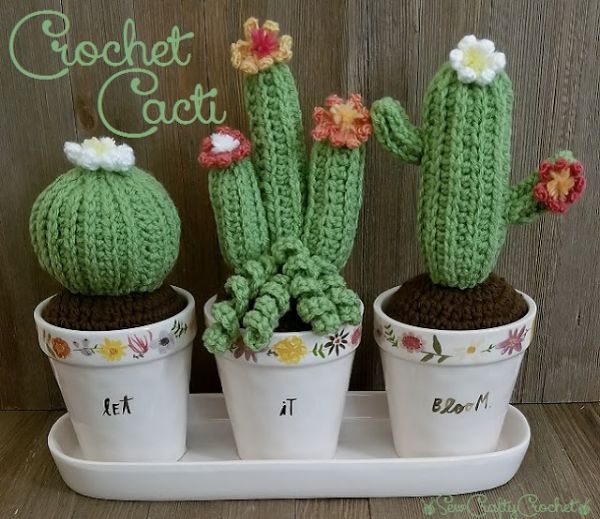 Three crochet cacti with flowers in pots.