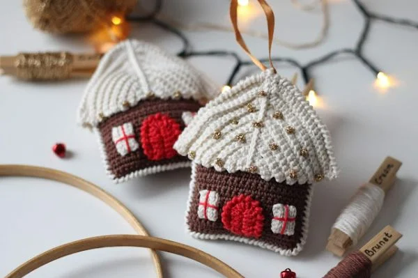 Two crochet gingerbread house Christmas ornaments.