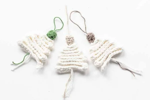 Three white crochet Christmas tree decorations.