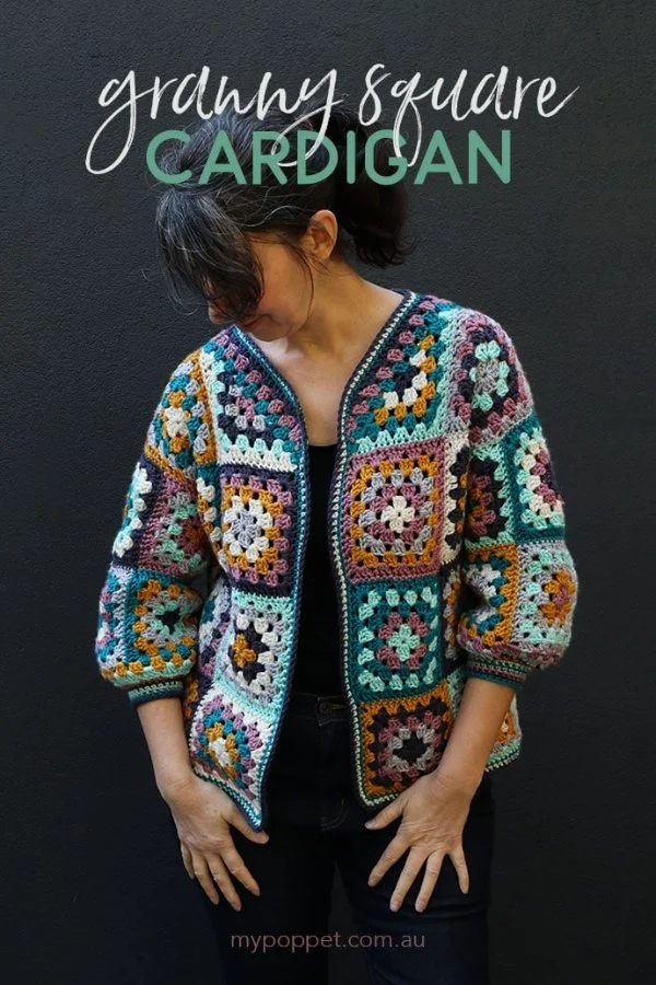 A brightly coloured Granny Square cardigan against a dark background.