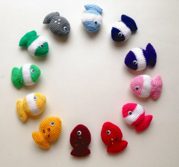 A collection of crochet fish cat toys in rainbow colours.