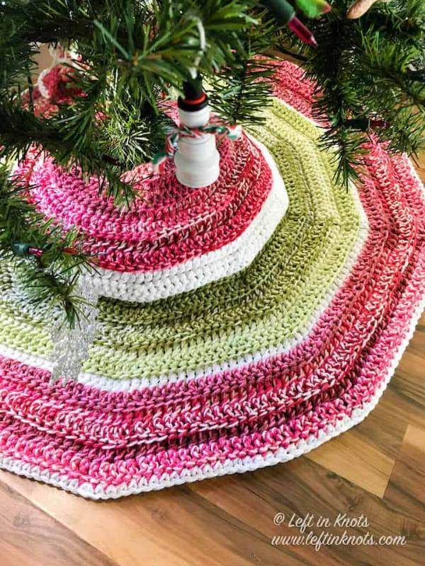 A green and red toned crochet Christmas tree skirt.
