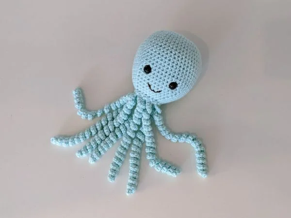 A pale blue crochet octopus toy.
