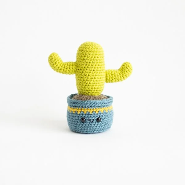 A corchet cactus in a blue crochet pot.