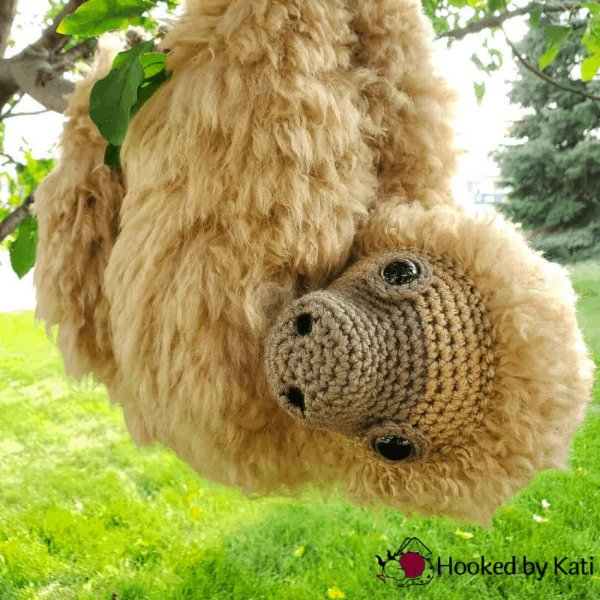 A crochet sloth with fluffy fur.