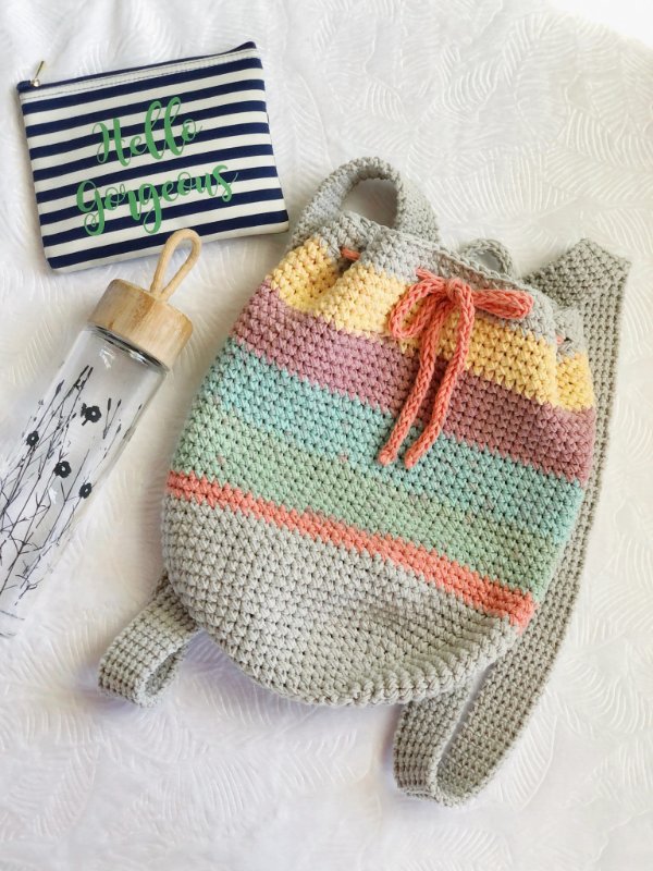 A crochet backpack with stripes and a drawstring.