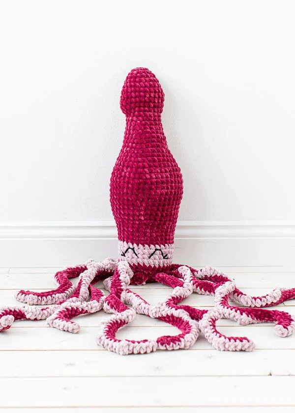A large crochet octopus in shades of pink.