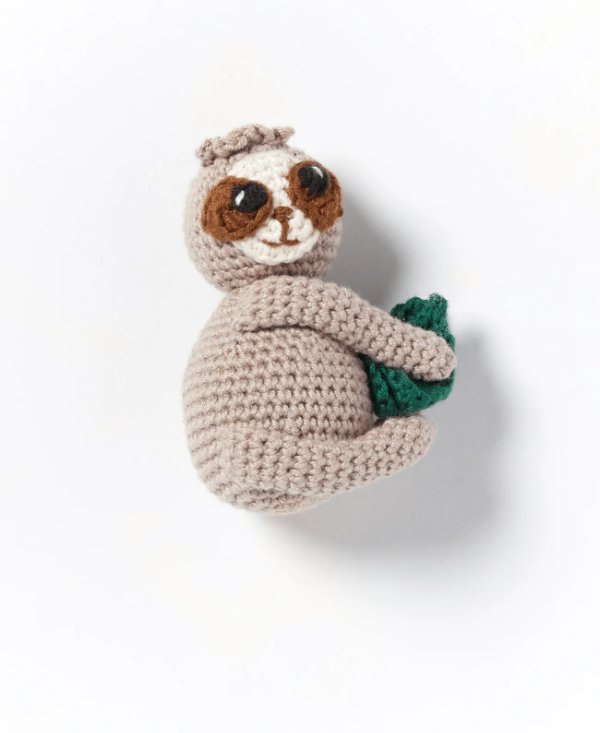 A small crochet sloth on a white background.