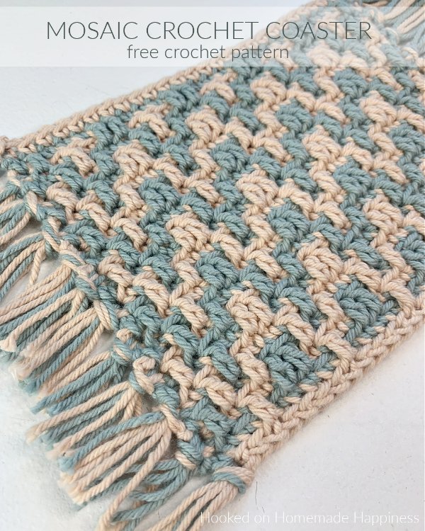 Blue and beige mosaic crochet coaster with fringing.