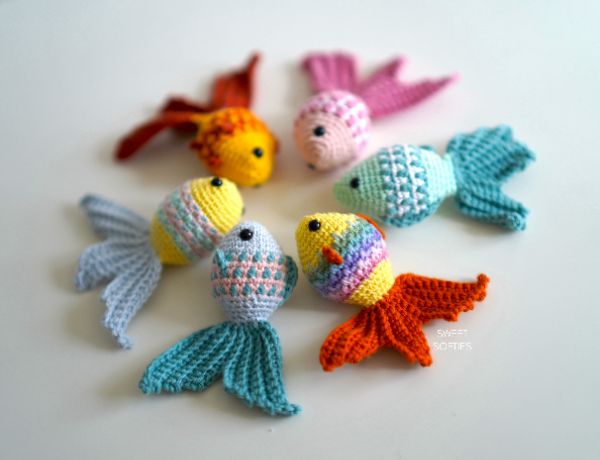 A collection of different coloured crochet goldfish with mosaic crochet scales.