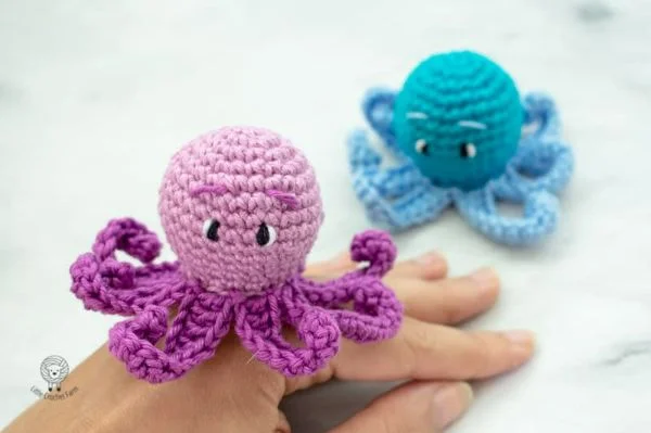Small crochet octopus sitting on a persons hand.