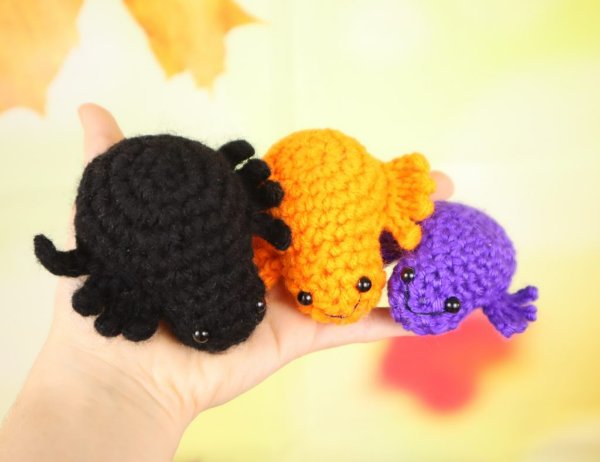 Three fat crochet spiders with short legs.