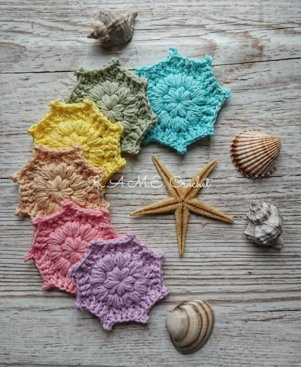 A collection rainbow, star-shaped crochet face scrubbies.