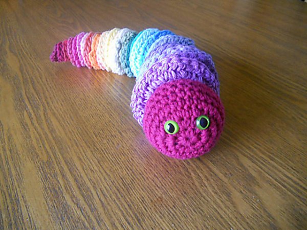 A rainbow coloured crochet caterpillar or worm.