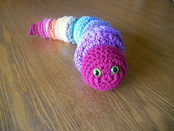 A rainbow coloured crochet caterpillar or worm.