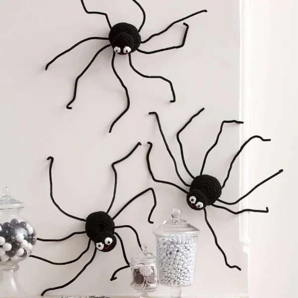 Crochet spiders climbing a wall.