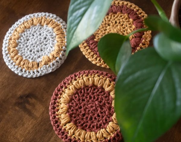 Crochet flower coasters in rust and mustard.